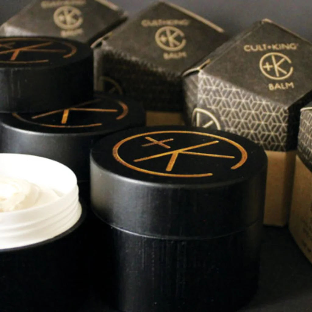 Black containers with gold logo and 'Cult+King' branding, surrounded by boxes.