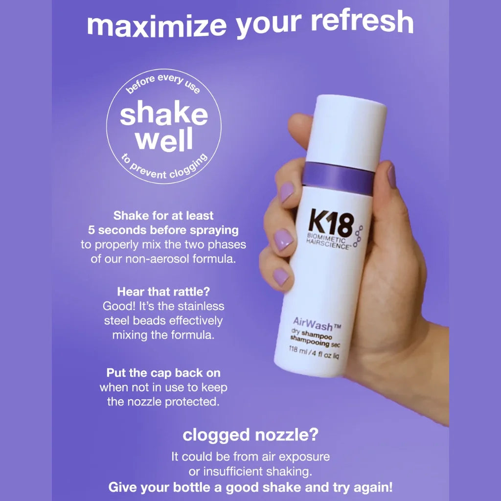A hand holding a white K18 AirWash hair cleansing bottle with a purple band, set against a purple background with instructional text about shaking the bottle before use. MANEPRINT