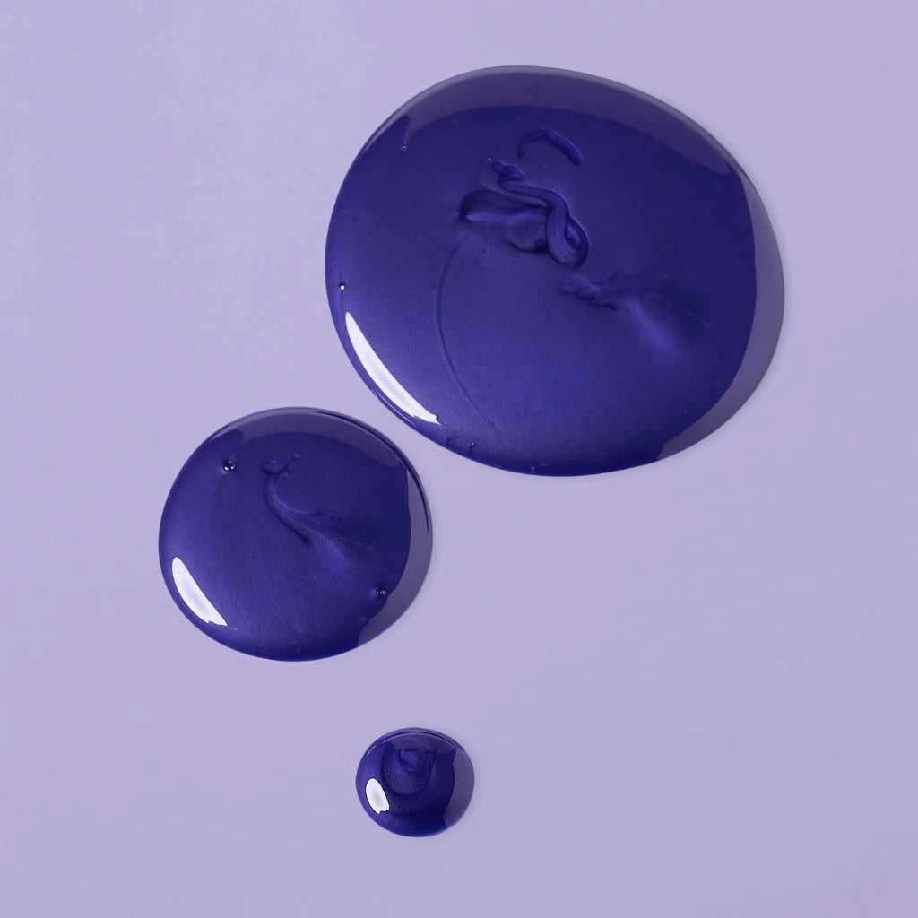 Three droplets of blue paint on a light purple background