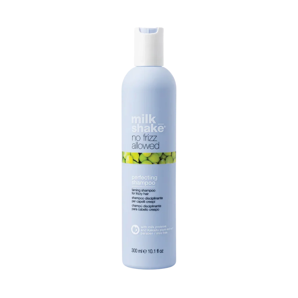 A 300 ml bottle of Milk Shake No Fizz Allowed Perfecting Shampoo, featuring a light blue bottle with a white cap and a green and yellow pattern band on the label, set against a plain white background.